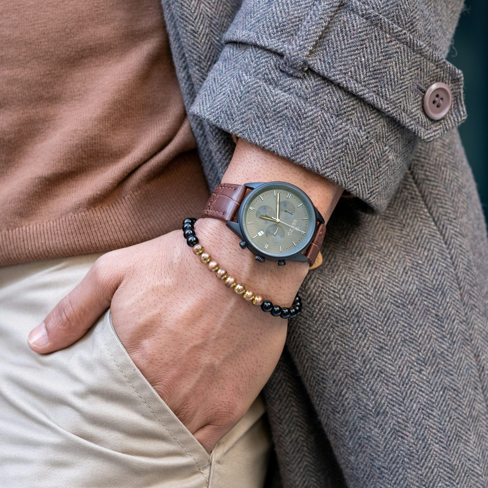 person wearing black leather strap analog watch